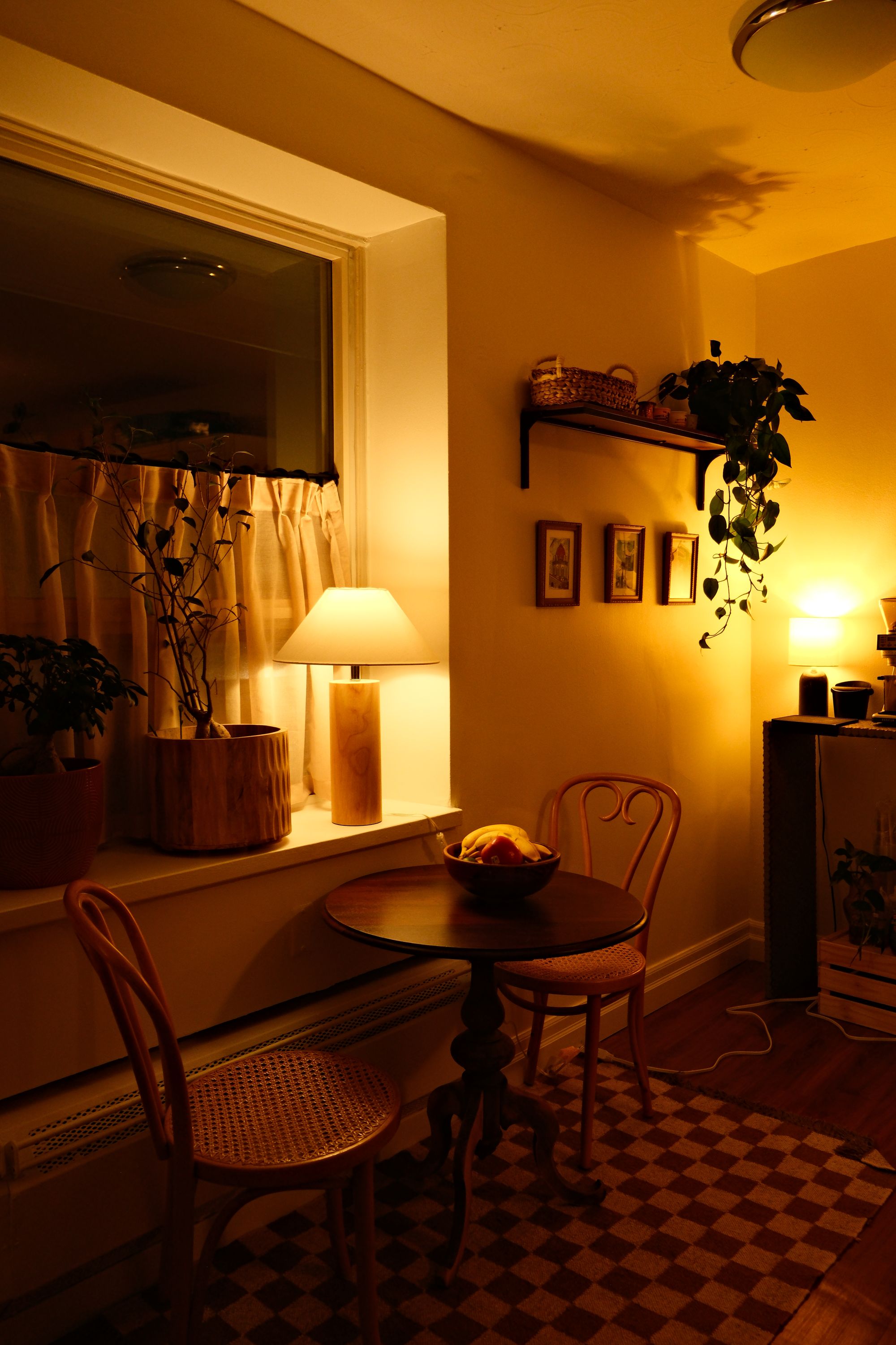 Lamp glowing at dusk above a dining table
