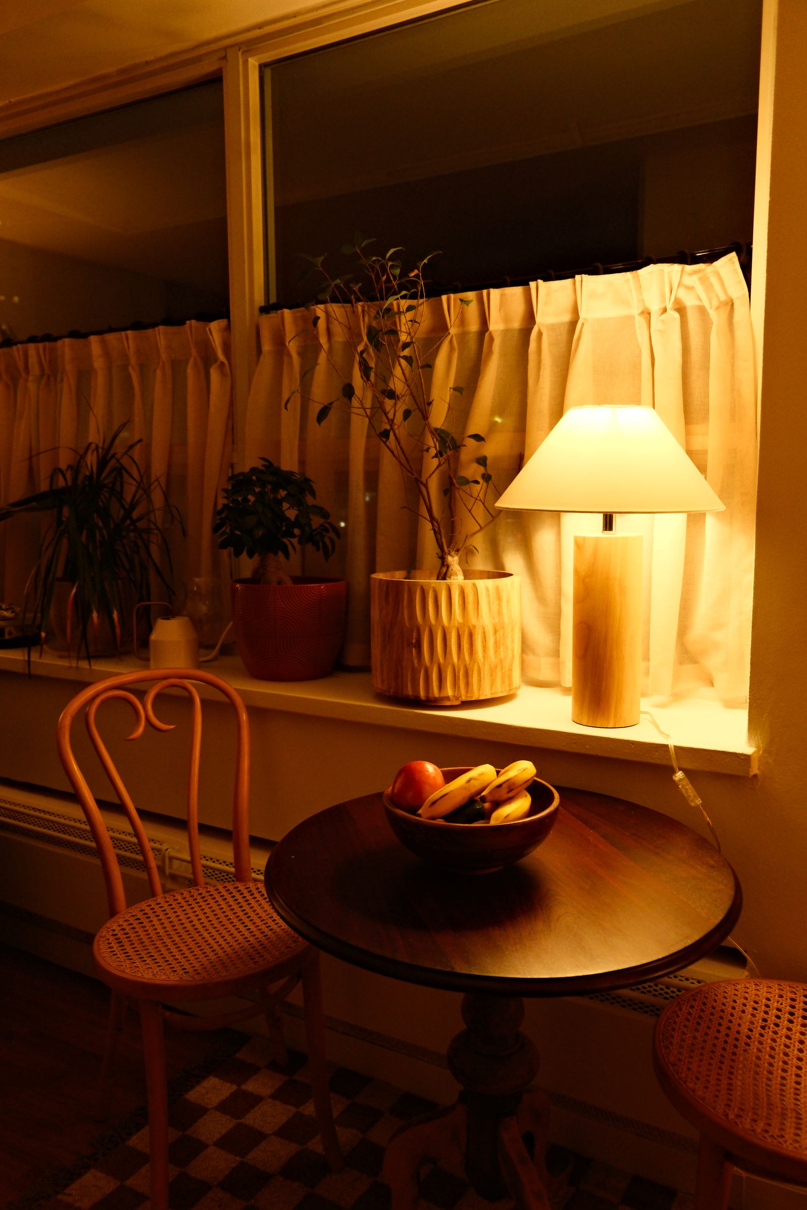 Shihnoo lamp on a side table beside a sofa and a full bookshelf
