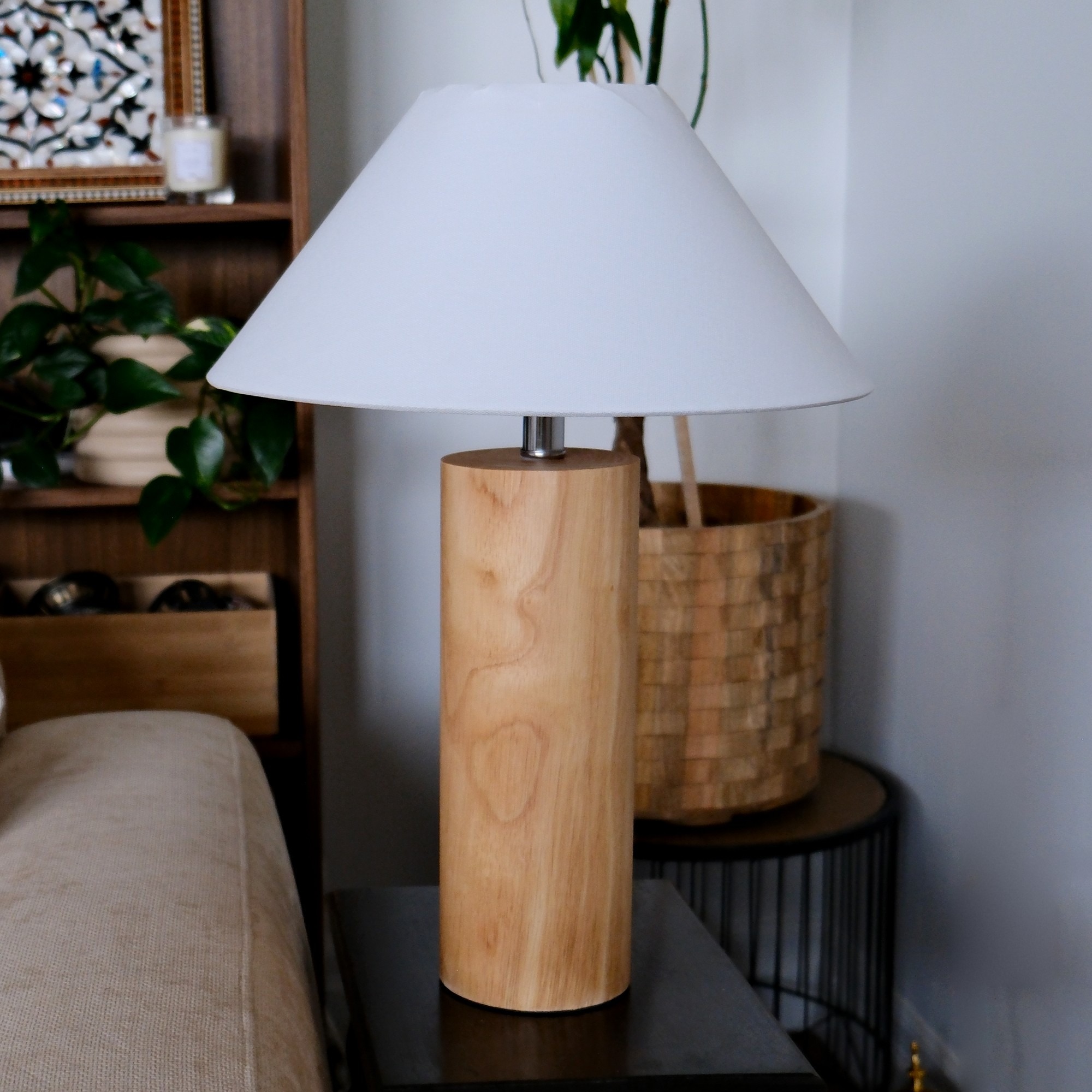 Shihnoo wooden table lamp with a solid natural wood base and off-white linen shade on a side table beside a sofa